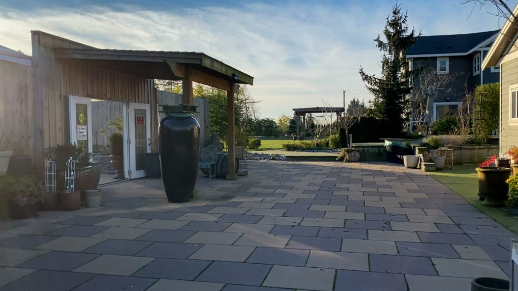 The entrance to the marquee tent area to the left with a stone patio and the guesthouse to the right